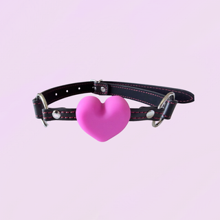 The gag is shown here with black strap, red stitching, silver hardware and pink heart gag