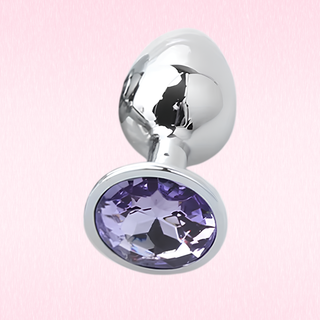 The Jewelled butt plug with violet base on a soft pink background