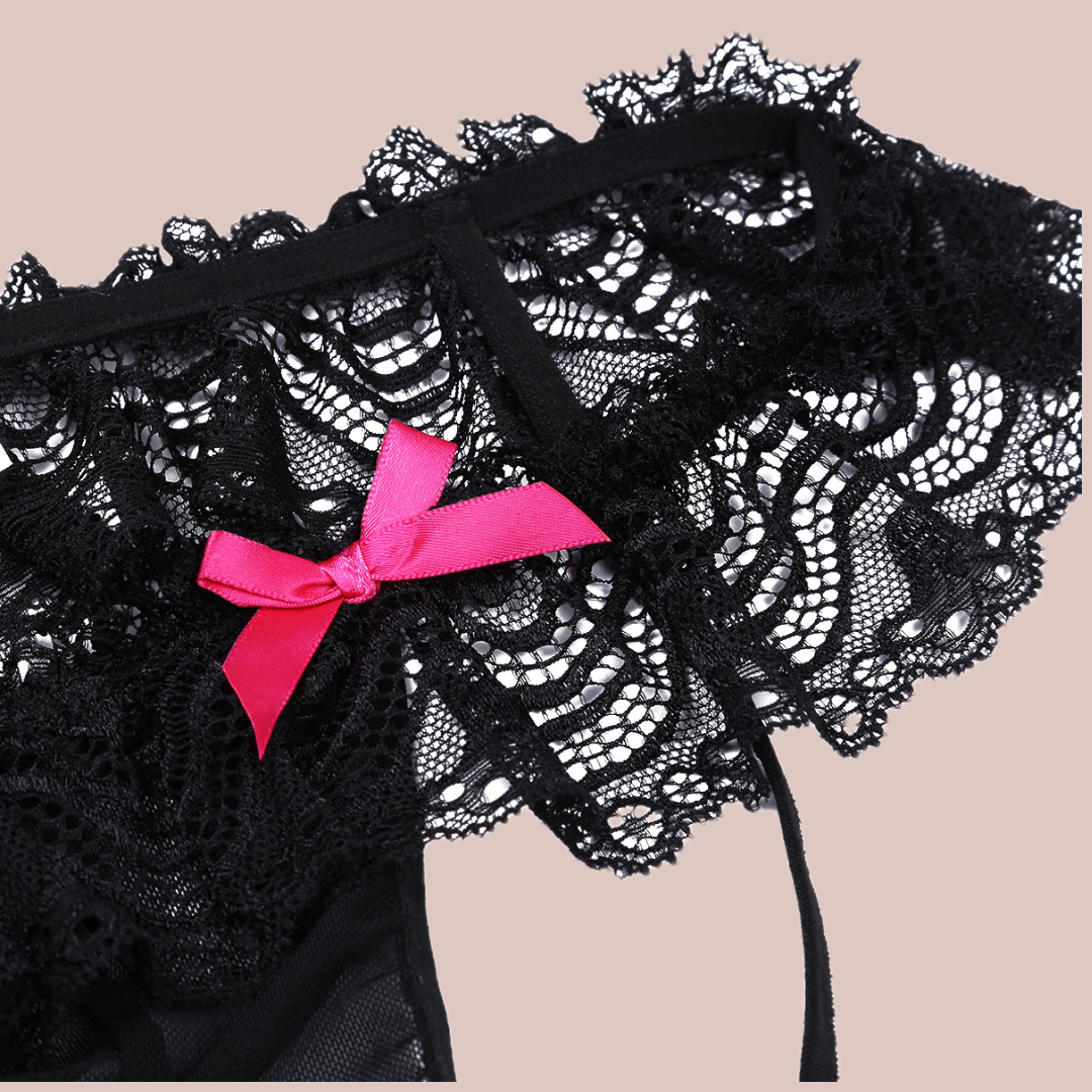 Close up of low rise hip style knickers with deep lace skirt, penis pouch and two decorative pink bows.