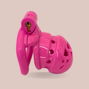 A side view of the pink Locked In Love Chastity Cage from House Of Chastity with the worlds LOCKED LIFE engraved across the front, it is shown here fully assembled with its base ring and integral lock.