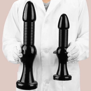 The Small and Large Monster Anal Plugs being held.