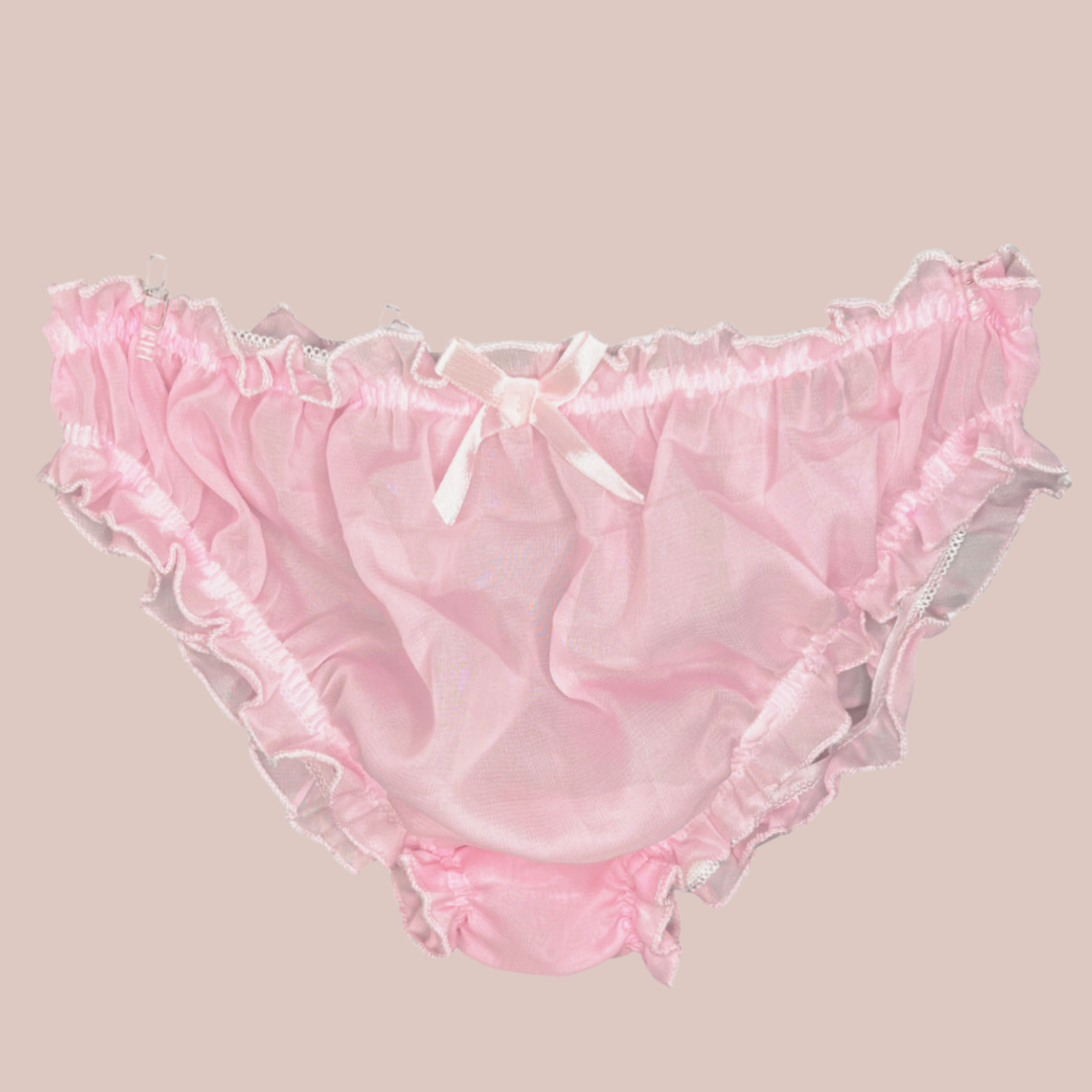 A close up of the soft pink see through bikini shaped panties for men, you can see the elasticated waist and legs, and the decorative matching pink bow. 