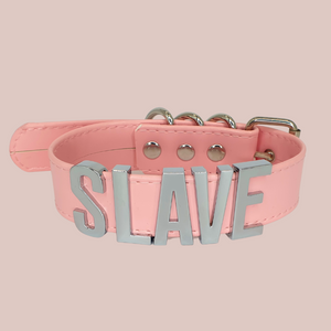 A front view of the pink Slave collar with matching silver lettering and fastenings.