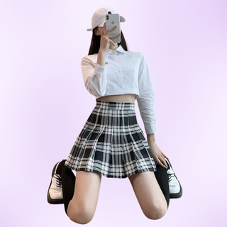 The black and white pleated mini skirt shown being modelled on a purple background