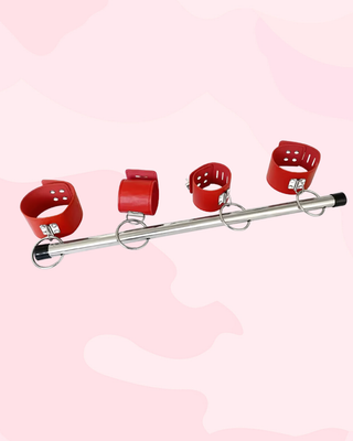 an alternate view of the wrist and ankle cuffs in red fixed on the spreader bar.