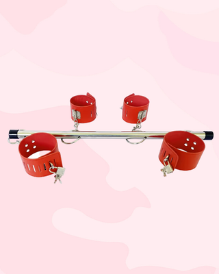 The red cuffs shown attached to the spreader bar and with their padlocks fixed in place.