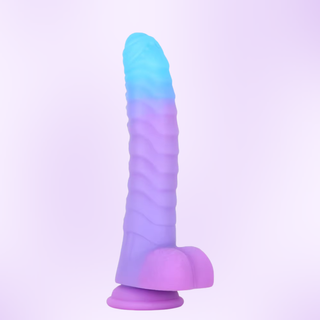 An upright view of the Aurora Scale dildo on a pink background