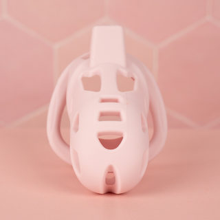 A front on view of the The Jeusn chastity cage in pink on a pink background