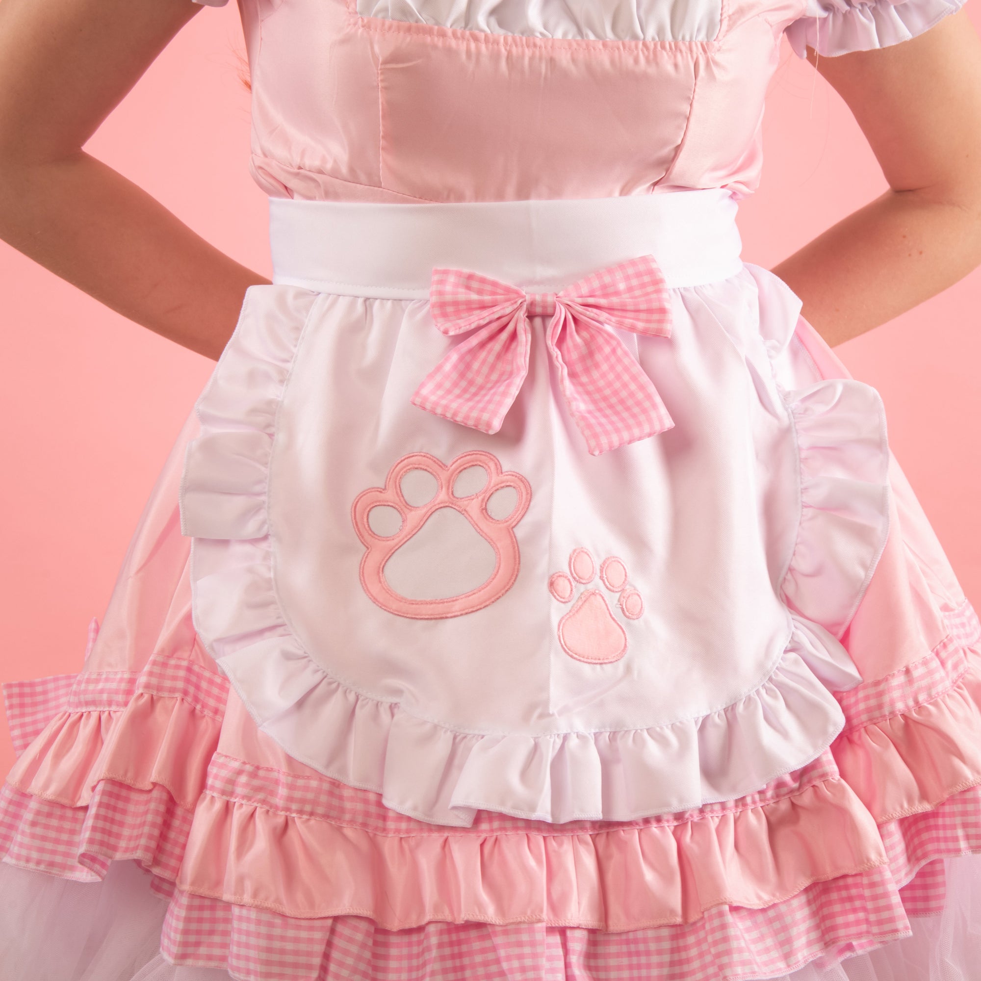 A close up of the apron with paw print detail and removable bow.