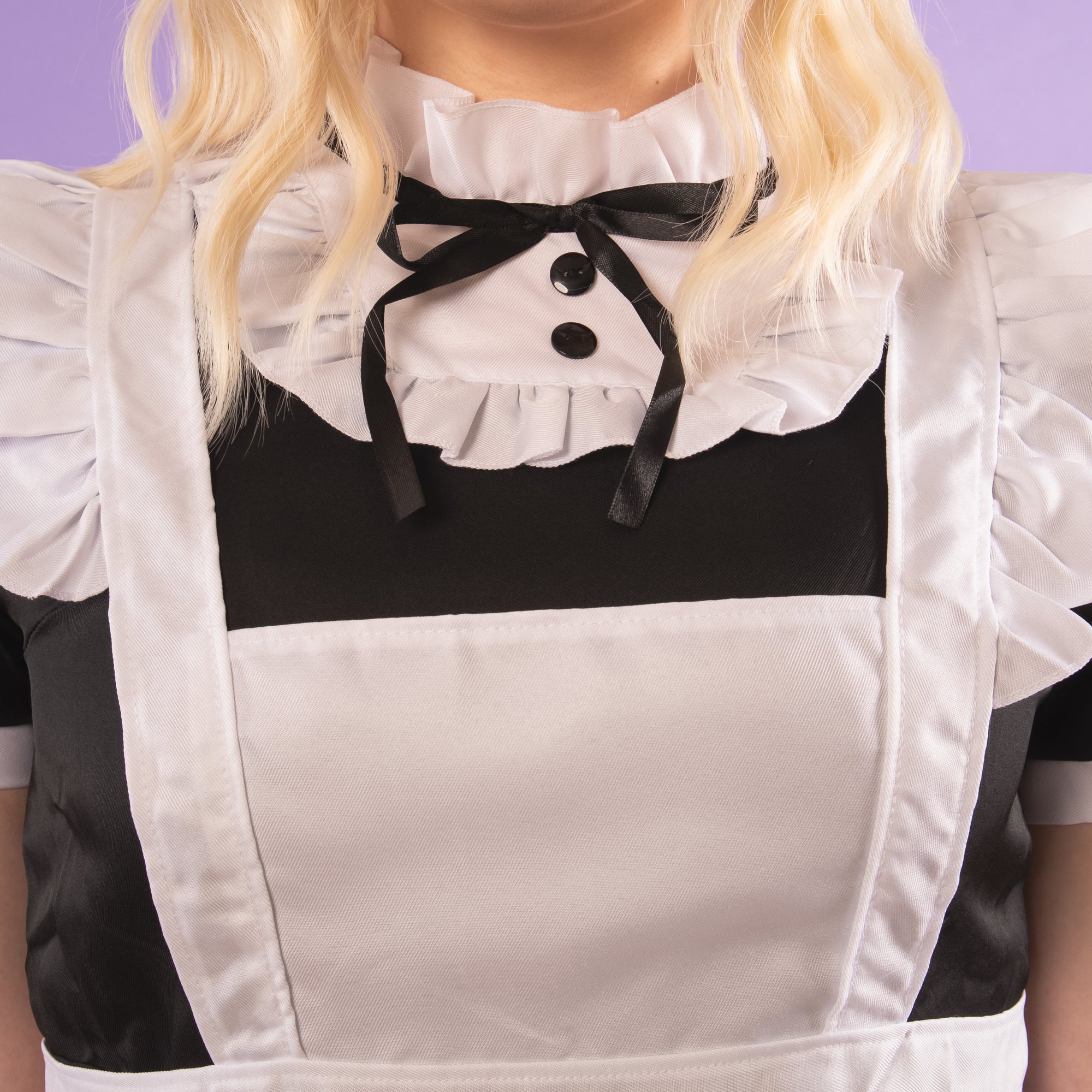 A close up of the high neck collar with decorative bow and buttons.