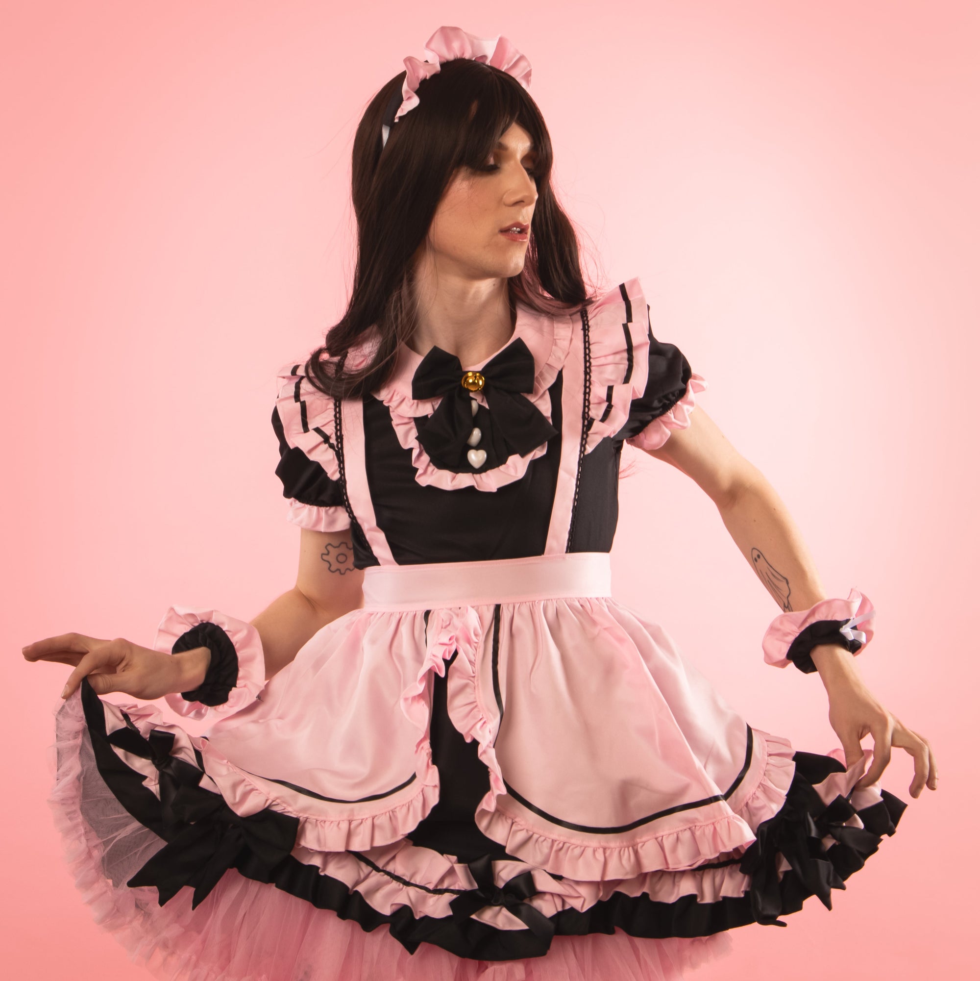 The dress comes with a pink and black apron, wrist bands and frilled headband. The black bows are designed to compliment the dress.