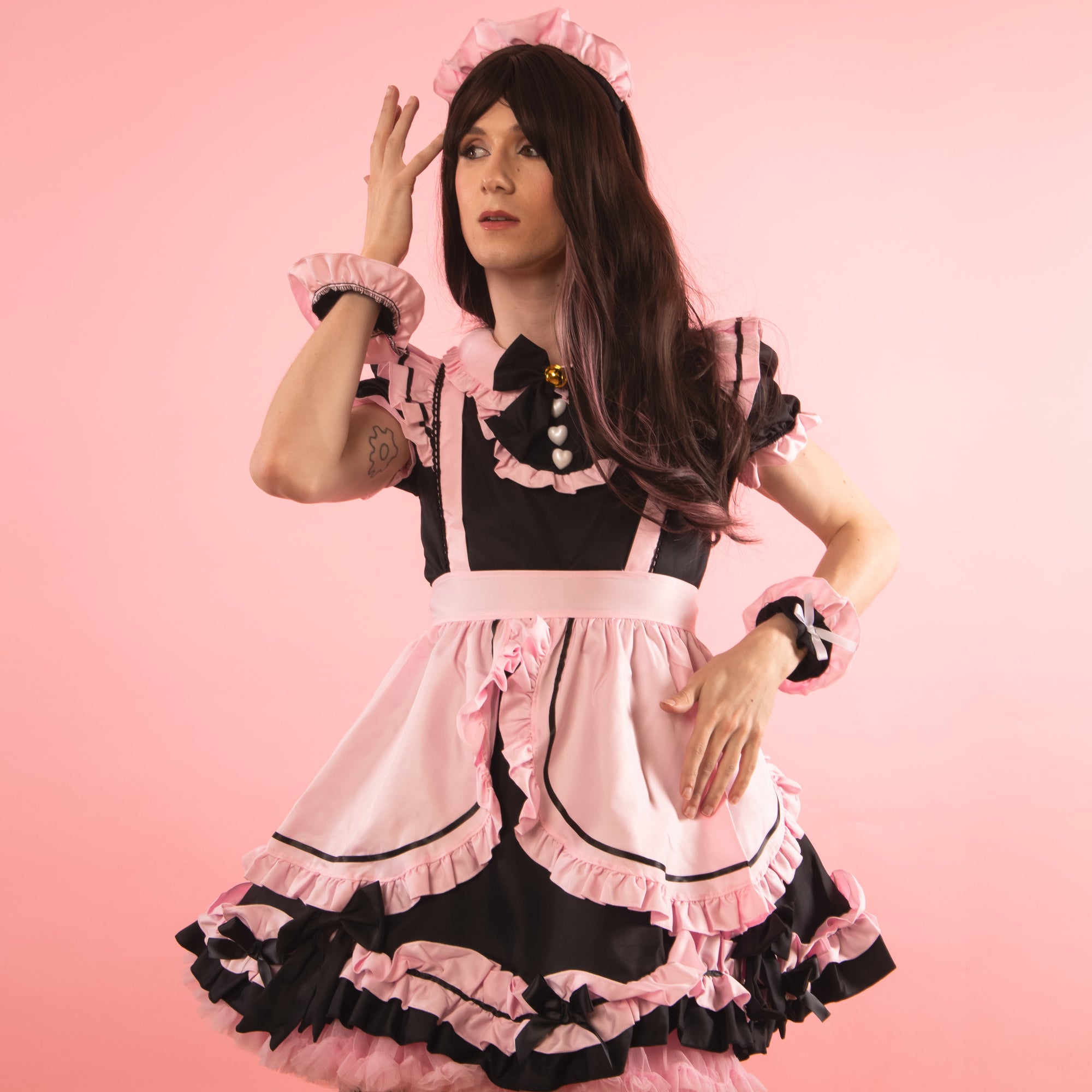 The stunning pink and black dress has frills galore, black bows and three white heart shaped buttons.