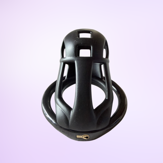 The Cobra Naja black chastity cage sitting on its base ring on a pink background