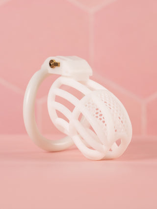 The White Detained Chastity Cage, you can see the lined body with the mesh affect to the top. The chastity cage is fitted to its base ring and the integral lock is in place.