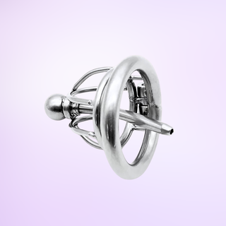 An angled view of the chastity cage, it is shown on a purple background and the urethral tube can be clearly seen.