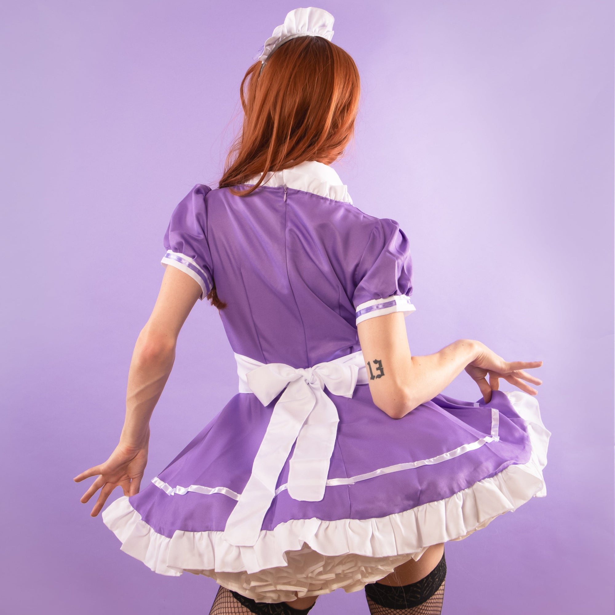 A rear view of the purple Suzie Maid Dress, the dress has a full-skirt.