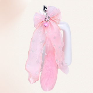 the butt plug with the pure pink tail and pink bow attachment. The paw print and bell can be seen at the centre of the bow.