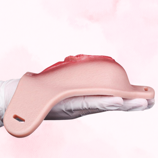 The vagina being held out flat to provide an idea of depth, it is shown on a pink background
