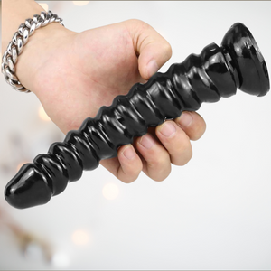 The black ribbed dildo from House Of Chastity is shown being held to give an idea of the size of the item.