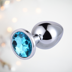 Large blue jewelled butt plug from a side on end view.