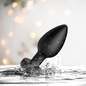 The black anal vibrator is shown rising out of water, to show that it is waterproof.