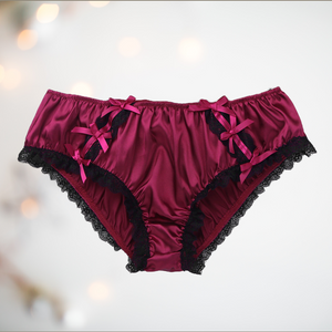 Shown unworn, Adult knickers for men, sissy, lgbt, unisex. Made in red wine satin with black lace detailing to the legs and panels on each side. There are also matching wine satin bows prettily applied.